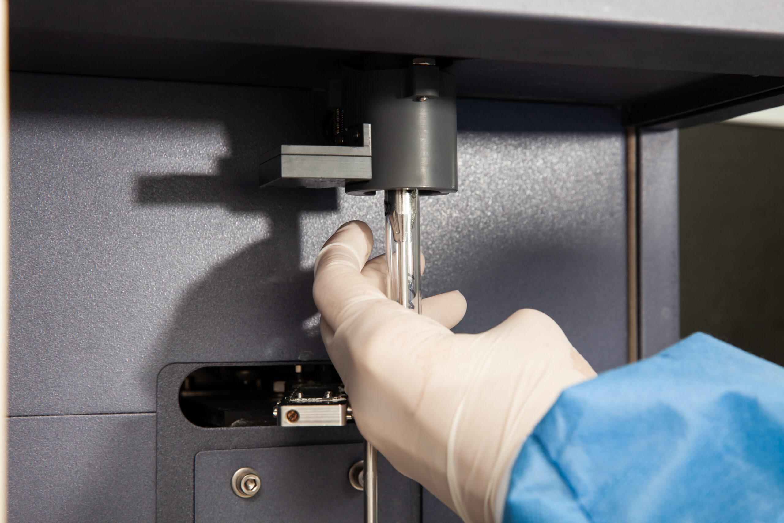 scientist loading a test tube containing a patient sample on the